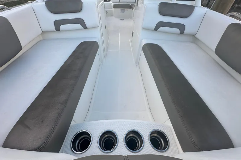 Slide: The Image of 2021 World Cat 230 SD boat interior with gray and white seating and cup holders. - 45