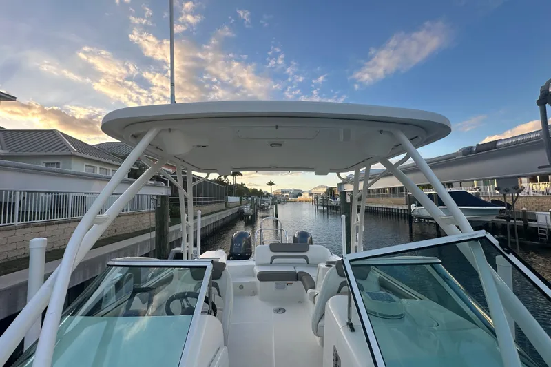 Slide: The Image of 2021 World Cat 230 SD boat docked in a serene marina at sunset. - 46
