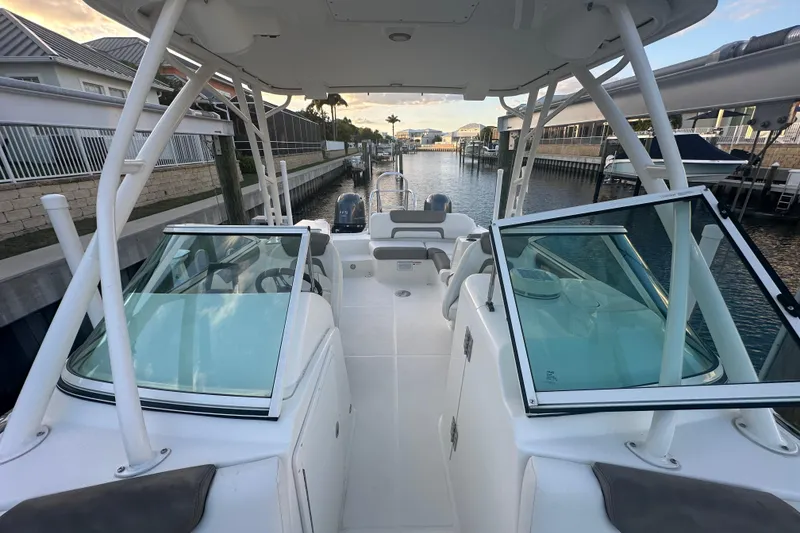 Slide: The Image of 2021 World Cat 230 SD boat docked in a marina, showcasing spacious deck and seating. - 47