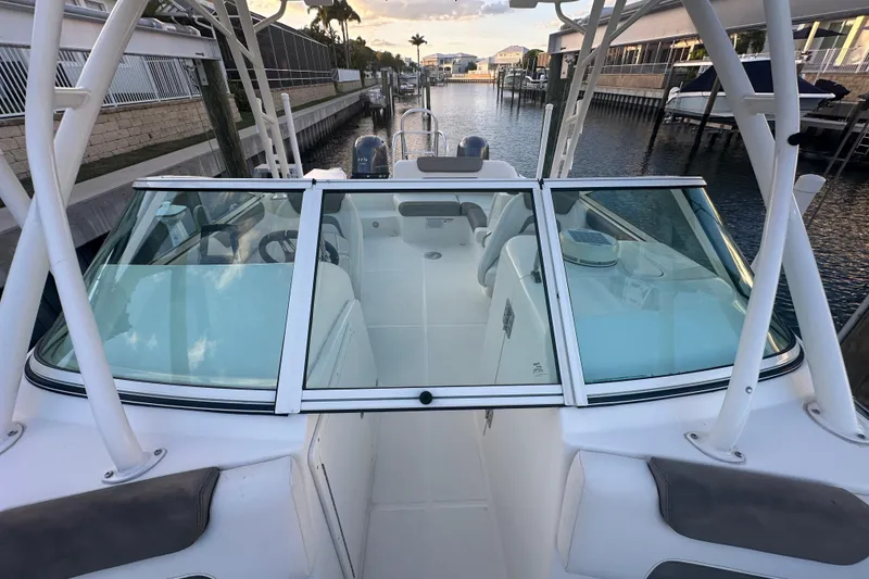 Slide: The Image of 2021 World Cat 230 SD boat docked in a canal, showcasing sleek design and spacious interior. - 48