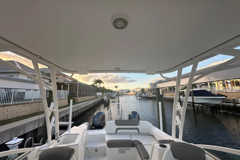 Slide: The Image of 2021 World Cat 230 SD boat docked in a serene canal setting at sunset. - 50