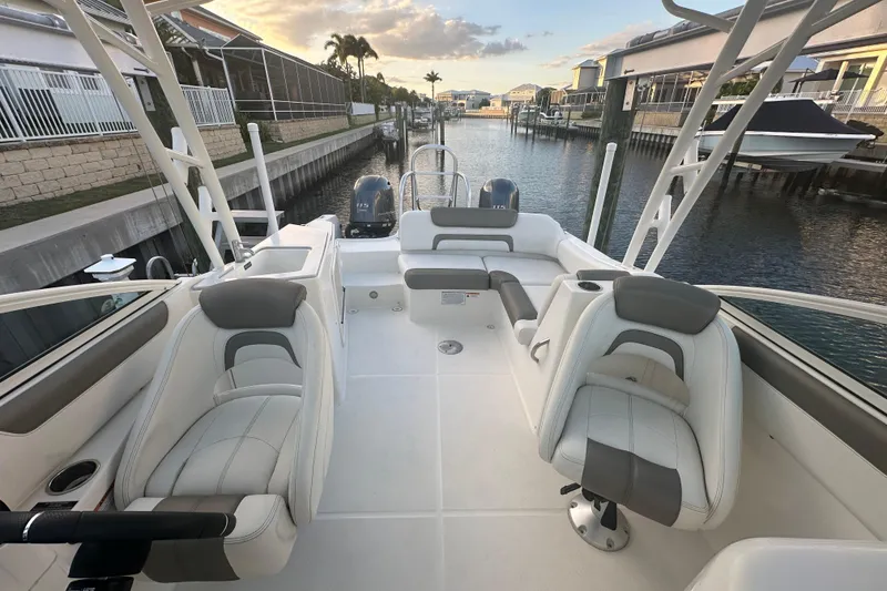 Slide: The Image of 2021 World Cat 230 SD boat interior with plush seating, docked in a serene canal setting. - 51