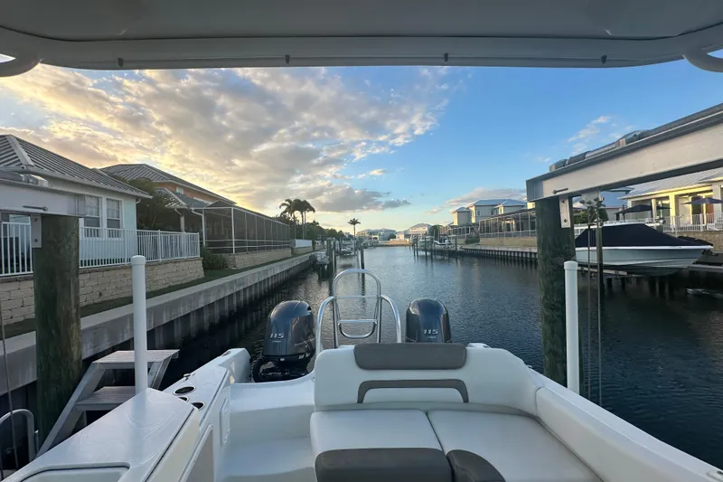 Slide: The Image of 2021 World Cat 230 SD boat docked in a serene canal at sunset. - 58