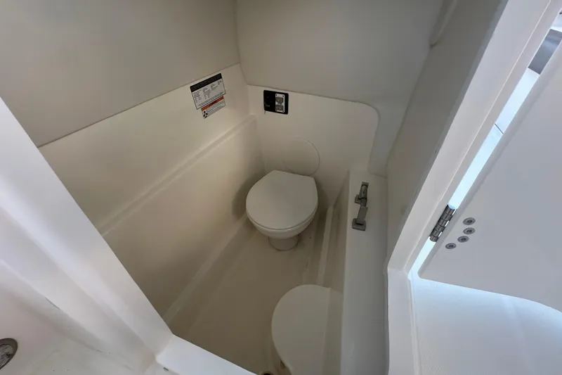 Slide: The Image of 2021 World Cat 230 SD boat interior bathroom with compact toilet and white walls. - 71