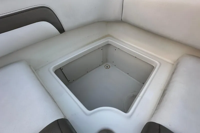 Slide: The Image of 2021 World Cat 230 SD boat storage compartment with white and gray seating. - 83