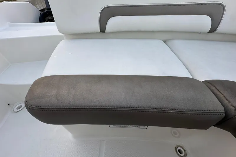 Slide: The Image of 2021 World Cat 230 SD boat seat with cushioned armrest, white and gray upholstery. - 84
