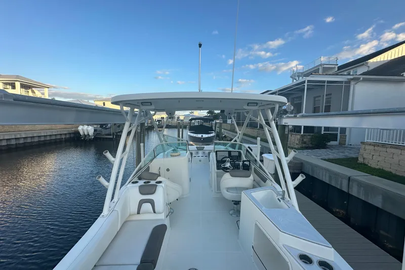 Slide: The Image of 2021 World Cat 230 SD boat docked in a serene canal setting. - 9