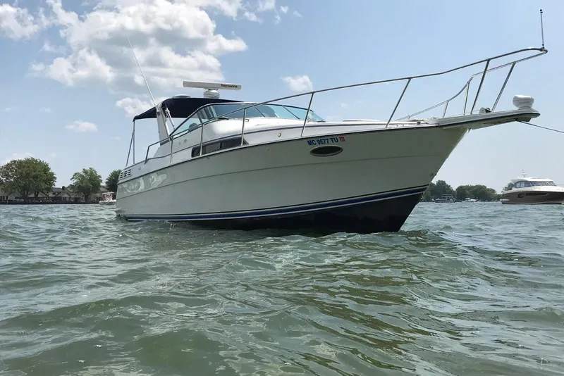 The Image of 1991 Four Winns 325 Express Vista boat on water under a clear sky. - 0