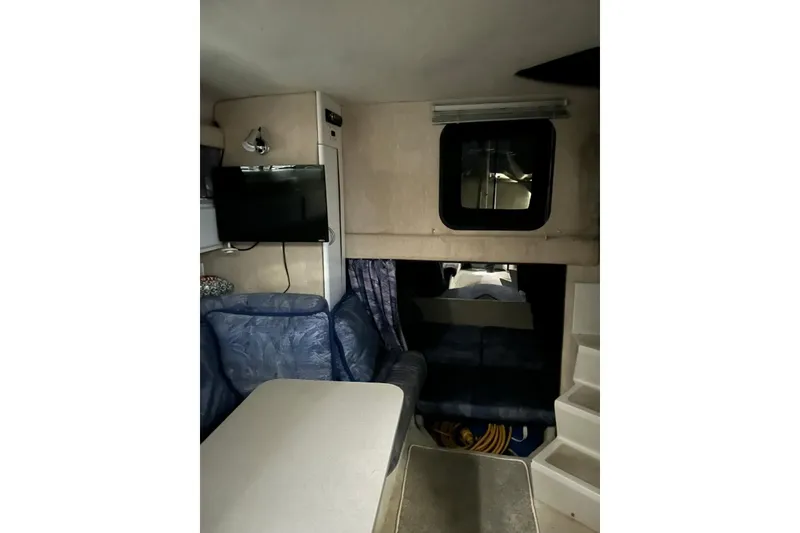Slide: The Image of Interior of 1991 Four Winns 325 Express Vista boat with seating and TV. - 11