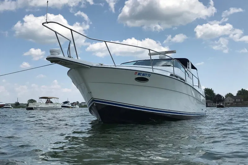 Slide: The Image of 1991 Four Winns 325 Express Vista boat on water under blue sky. - 14