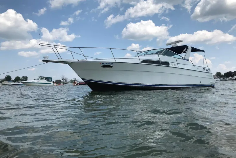 Slide: The Image of 1991 Four Winns 325 Express Vista boat on water under blue sky. - 15