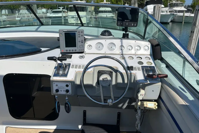 Slide: The Image of 1991 Four Winns 325 Express Vista boat dashboard with steering wheel and navigation equipment. - 3