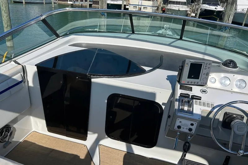 Slide: The Image of 1991 Four Winns 325 Express Vista boat cockpit with navigation controls and steering wheel. - 7