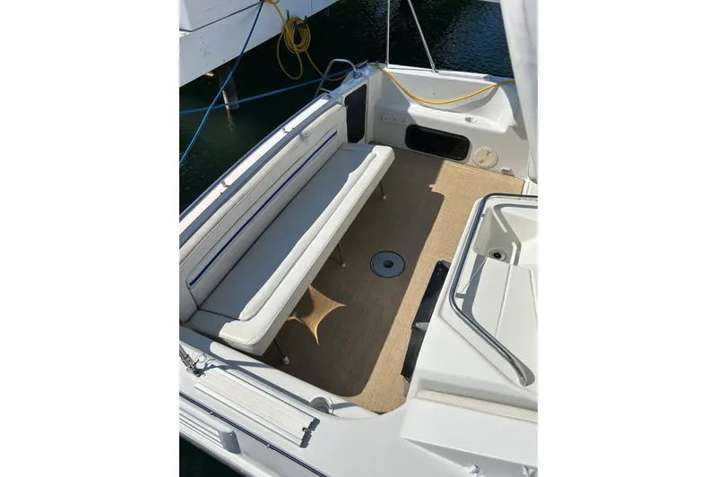 Slide: The Image of 1991 Four Winns 325 Express Vista boat interior with cushioned seating and carpeted floor. - 8