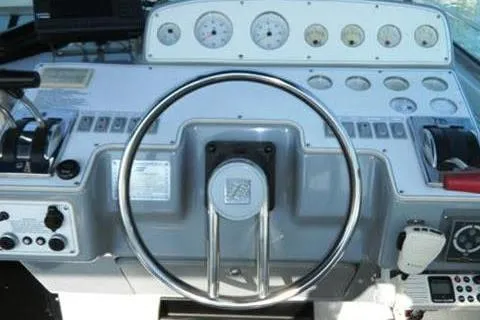 Slide: The Image of 1991 Four Winns 325 Express Vista boat dashboard with steering wheel and gauges. - 9