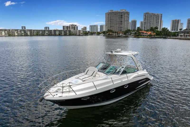 The Image of 2014 Monterey 320 Sport Yacht on calm water with city skyline backdrop. - 0