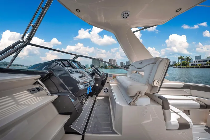 Slide: The Image of 2014 Monterey 320 Sport Yacht interior with modern helm, luxurious seating, and scenic waterfront view. - 20