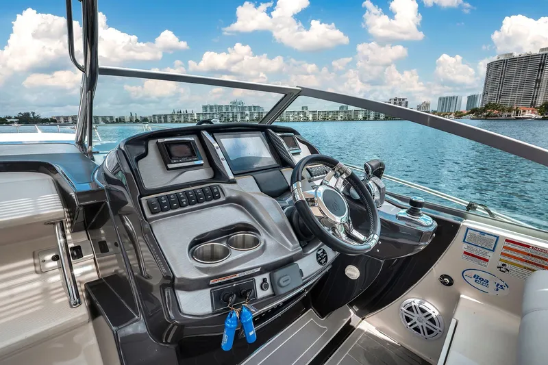 Slide: The Image of Cockpit view of 2014 Monterey 320 Sport Yacht on a sunny day, overlooking water and cityscape. - 23