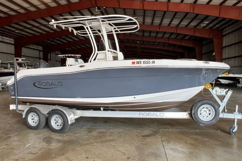 Slide: The Image of 2023 Robalo R200 Center Console boat on trailer in indoor storage facility. - 0