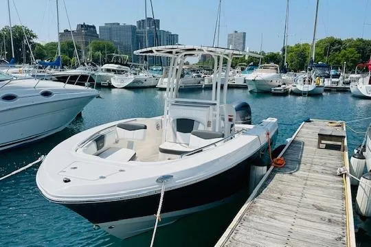 Slide: The Image of 2023 Robalo R200 Center Console boat docked in a marina with city skyline. - 16