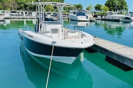 Slide: The Image of 2023 Robalo R200 Center Console boat docked in a marina with clear blue water. - 18