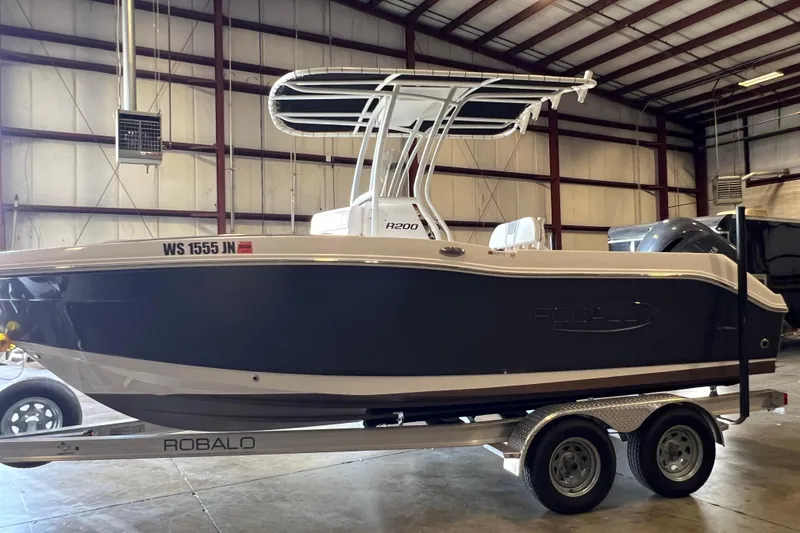 Slide: The Image of 2023 Robalo R200 Center Console boat in warehouse, on trailer, side view. - 4