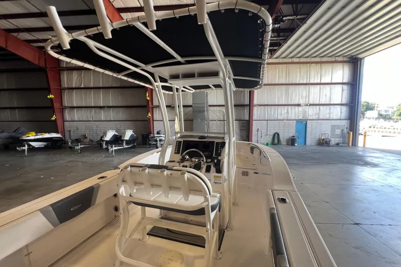 Slide: The Image of 2023 Robalo R200 Center Console boat in a spacious indoor storage facility. - 9