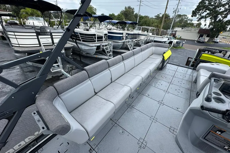 Slide: The Image of 2023 Sea-Doo Switch Cruise 21 with spacious seating, docked among other boats. - 10