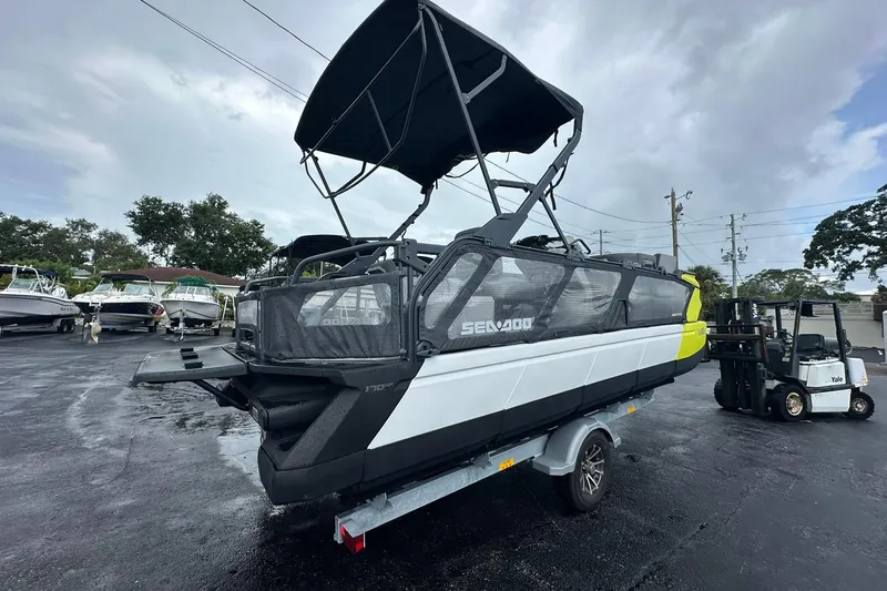 Slide: The Image of 2023 Sea-Doo Switch Cruise 21 on trailer, parked outdoors under cloudy sky. - 2