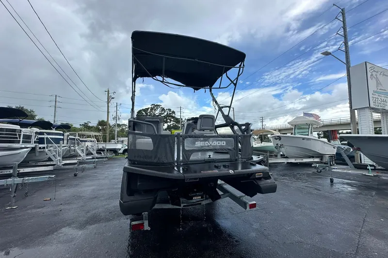 Slide: The Image of 2023 Sea-Doo Switch Cruise 21 boat displayed in a dealership lot under cloudy skies. - 4