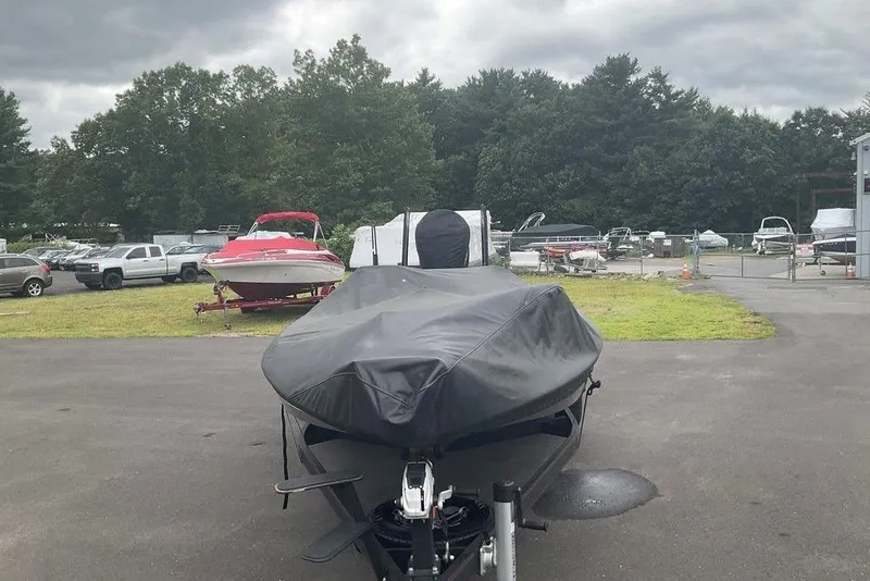 Slide: The Image of 2017 Skeeter FX21 LE boat covered, parked outdoors with other vehicles and boats nearby. - 10