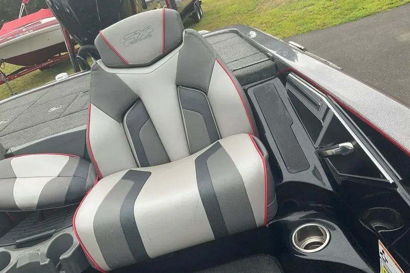 Slide: The Image of 2017 Skeeter FX21 LE boat seat with gray and red accents, cup holder, and storage. - 36