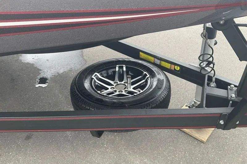 Slide: The Image of 2017 Skeeter FX21 LE boat trailer with a spare tire on pavement. - 45