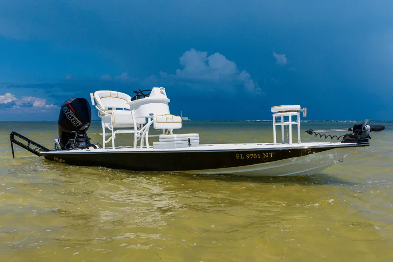 Slide: The Image of 2008 Lake & Bay Boca Grande 20 boat on calm water under a cloudy sky. - 11