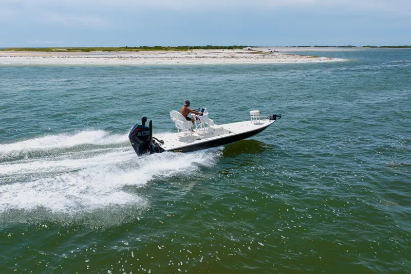 Slide: The Image of 2008 Lake & Bay Boca Grande 20 boat speeding on open water near a sandy shoreline. - 23