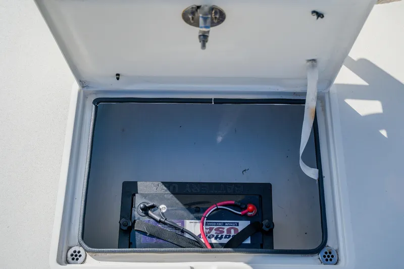 Slide: The Image of Battery compartment of 2008 Lake & Bay Boca Grande 20 boat, featuring a secured battery. - 32