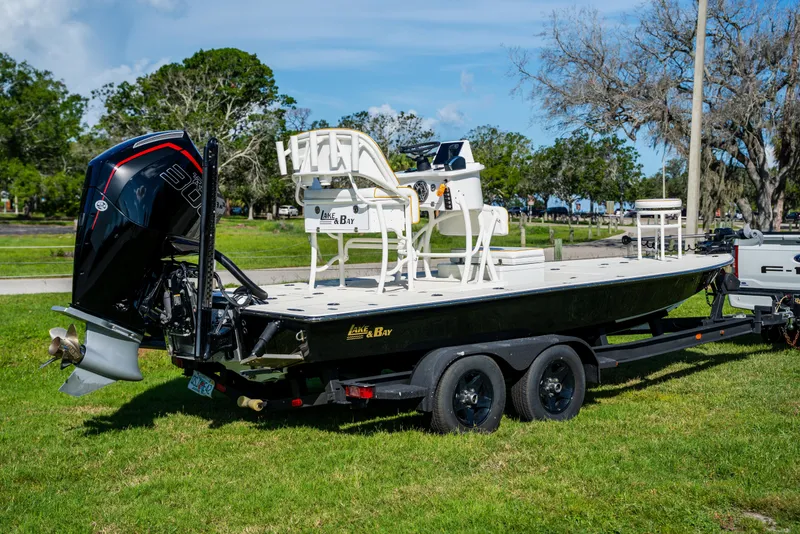 Slide: The Image of 2008 Lake & Bay Boca Grande 20 boat on trailer, parked on grass, with trees in background. - 9