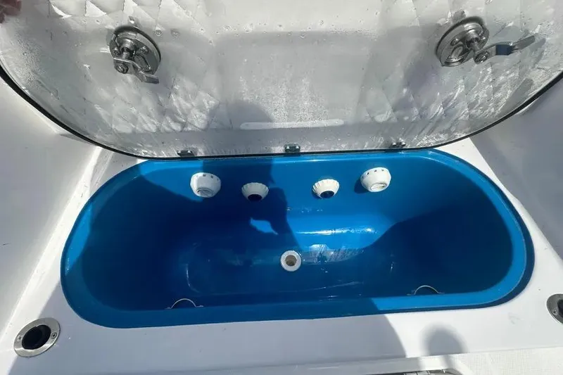 Slide: The Image of Open livewell compartment on 2025 HCB 39 Speciale boat, featuring blue interior and lid. - 25