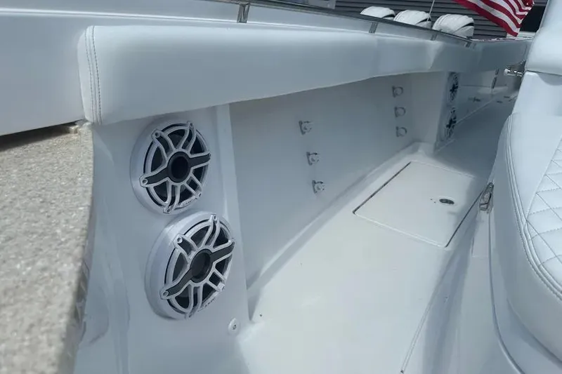 Slide: The Image of 2025 HCB 39 Speciale boat interior with speakers and seating, featuring sleek white design. - 30