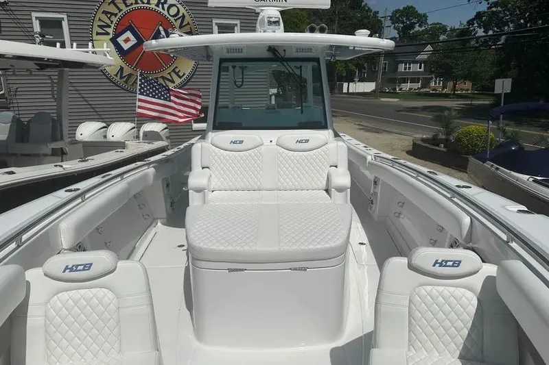 Slide: The Image of 2025 HCB 39 Speciale boat with luxurious white seating and American flag in background. - 4