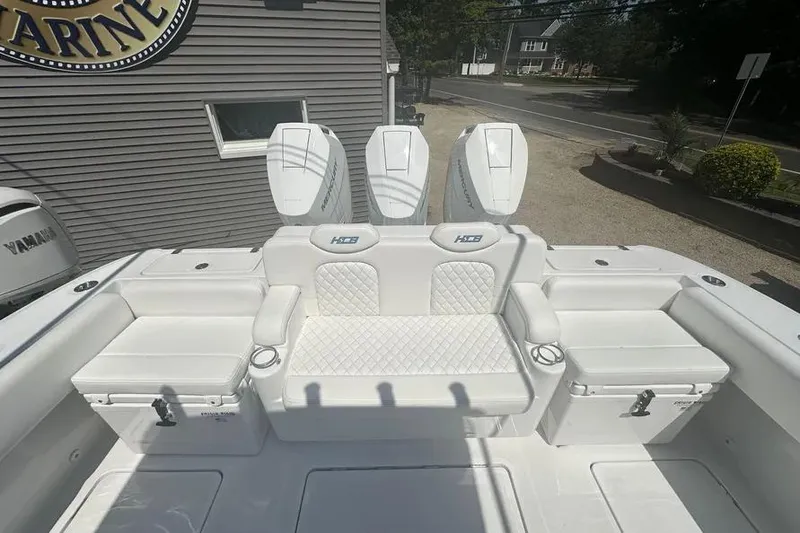 Slide: The Image of 2025 HCB 39 Speciale boat interior with white seating and triple outboard engines. - 7