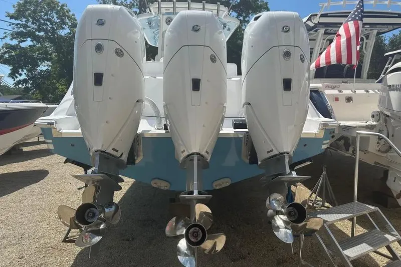 Slide: The Image of 2025 HCB 39 Speciale boat with triple outboard engines, American flag in background. - 8