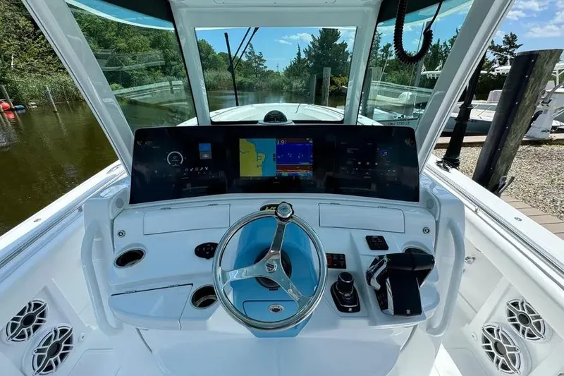 Slide: The Image of 2025 HCB 39 Speciale boat cockpit with modern navigation system and sleek steering wheel. - 9