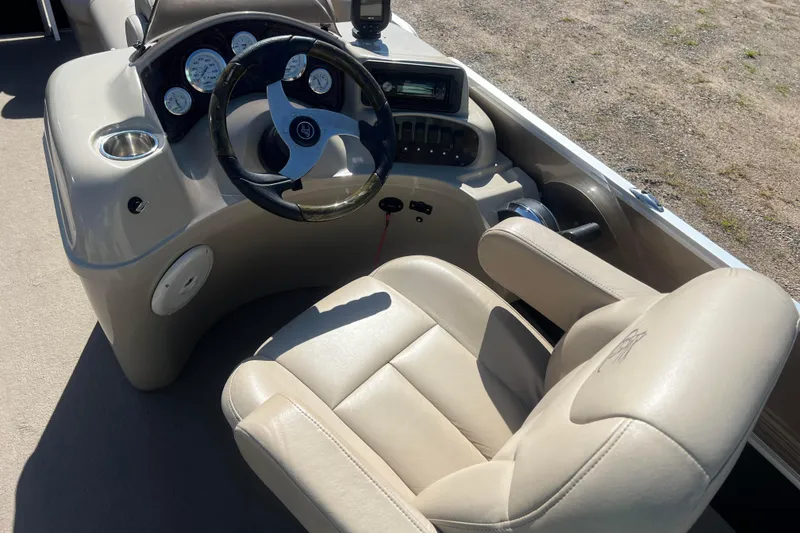 Slide: The Image of 2014 Misty Harbor 2285 Biscayne Bay CU boat helm with beige captain's chair and control panel. - 34
