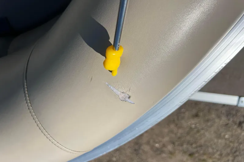 Slide: The Image of Damaged upholstery on 2014 Misty Harbor 2285 Biscayne Bay CU boat seat with repair tool. - 47