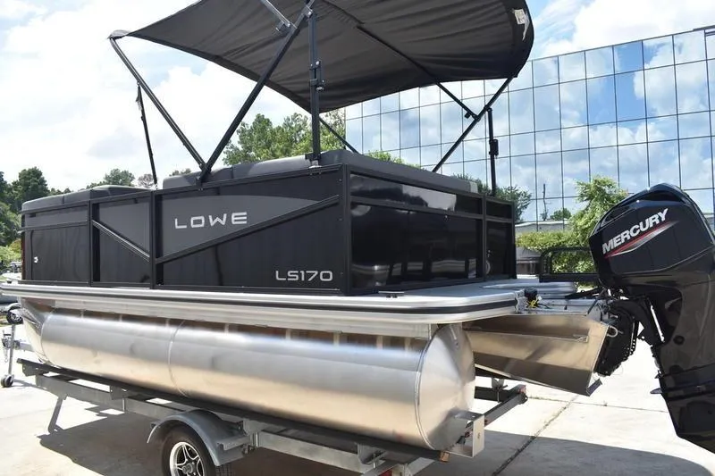 Slide: The Image of 2026 Lowe LS 170 pontoon boat, docked with metal ladder, sleek black design. - 11