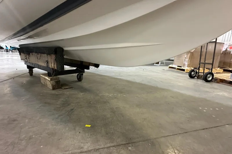 Slide: The Image of 2022 Walker Bay Venture 16 boat hull on a dolly in a warehouse. - 11