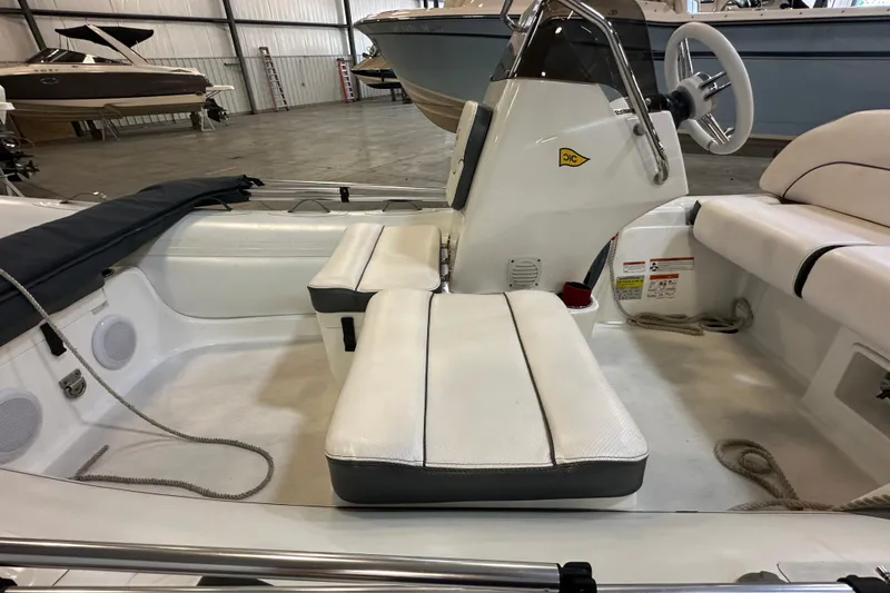Slide: The Image of 2022 Walker Bay Venture 16 boat interior with white seating and steering console. - 13