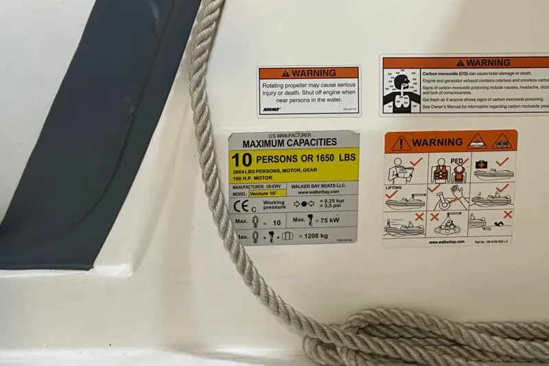 Slide: The Image of 2022 Walker Bay Venture 16 safety and capacity warning labels with rope detail. - 16