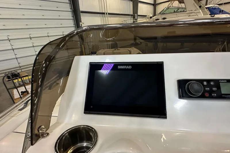 Slide: The Image of 2022 Walker Bay Venture 16 dashboard with Simrad display and Fusion audio controls. - 18